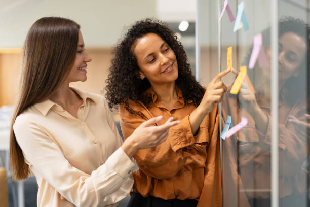istock Business people using sticky notes working together in modern office. Teamwork, scrum, agile 1730968151