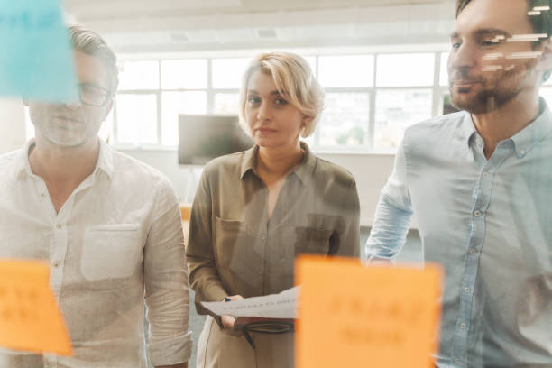 istock Businesspeople using sticky notes, agile methodology for productivity working together in office 1730968163