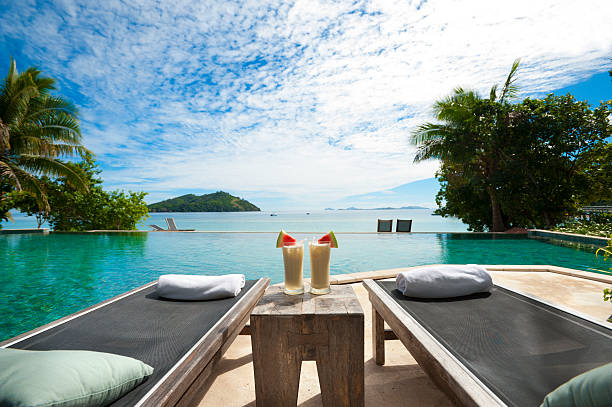 A lounge beside the pool with cocktails on table Sun lounges and cocktails by the pool in a tourist resort koh tao stock pictures, royalty-free photos & images