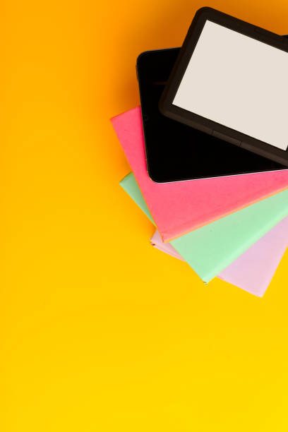 istock Digital tablet on stack of books on yellow background 1730982110