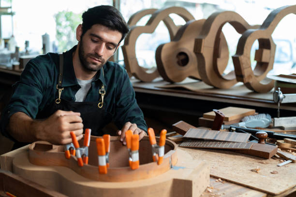 istock Luthier Inspects Kerfin Lining on Guitar Body 1730985480