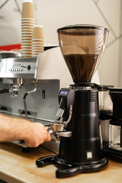 istock Coffee Grinding process with machine, barista hand hold grinding fresh roasted coffee bean 1730988800