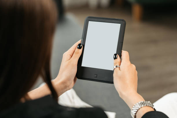 istock Young woman sitting the couch with an e-book 1730993744