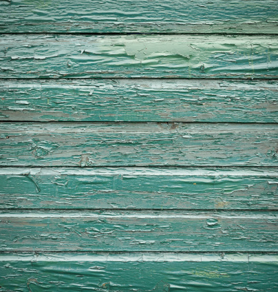 Green painted wooden planks in a severely weathered condition.