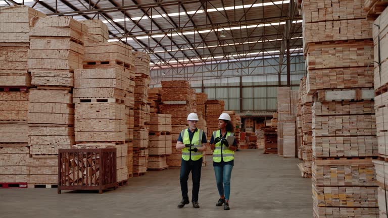 worker or inspector is checking the quality and quantity of goods in a pallet wood factory.