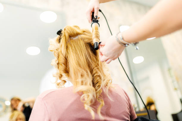 istock Hairstylist Using Curling Iron in Salon 1731014279