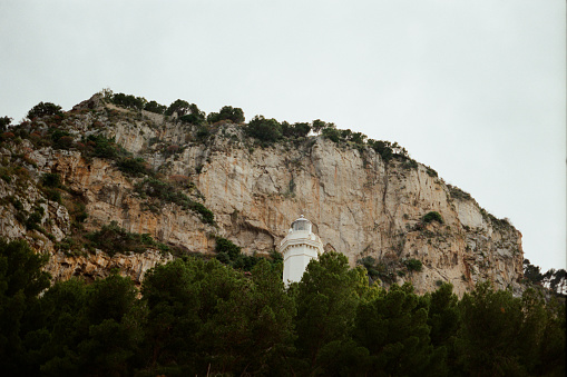 Lighthouse near limestone cliff in Cefalu, Sicily, Italy