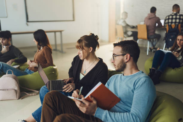 istock Couple of students e-learning at casual classroom. 1731052420