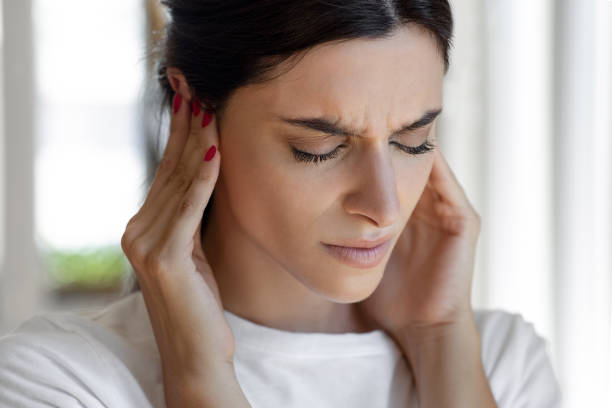 kobieta ma szumy uszne, hałas gwiżdże w uszach - emotional stress irritation hands covering ears displeased zdjęcia i obrazy z banku zdjęć