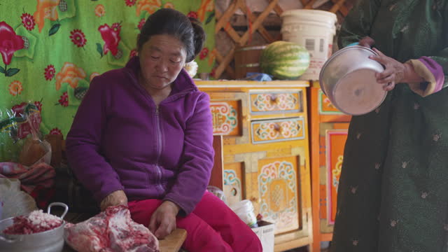 Mongolian women preparing traditional food buuz, dumpling in yurt