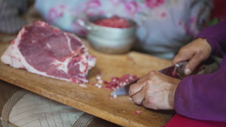 Mongolian woman cutting lamb meat preparing buuz