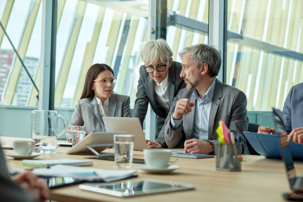 istock Business team talking while working on laptop in the office. 1731065933