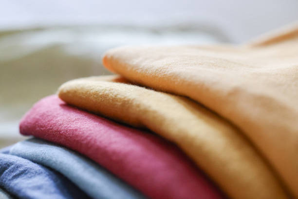 Folded clothes and quilt on bed. Mastercard Creative
