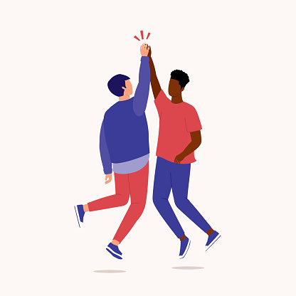 Two Young Men Of Mixed Race Jumping Up In High Five Gesture With Slapping Each Other’s Palms With Their Arms Raised. Isolated On Color Background.