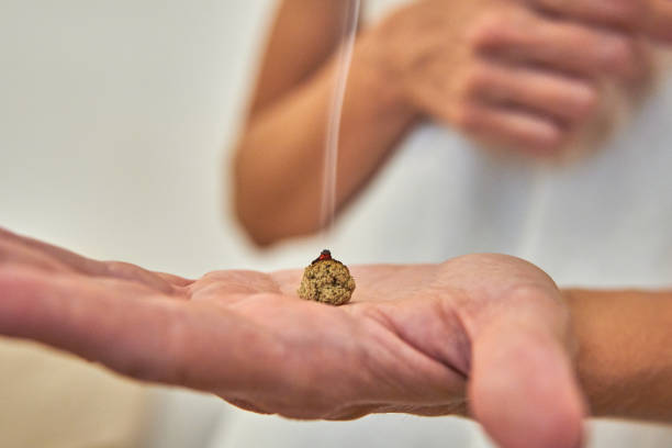 cono de moxa para moxibustión y tratamiento de acupuntura ardiendo en la mano abierta del terapeuta - women open traditional culture human hand fotografías e imágenes de stock