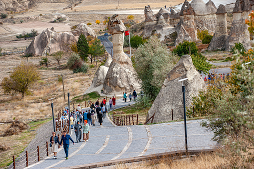 Nevşehir, Turkey - October 17, 2021: Tourists walking to the fairy chimneys in Paşabağı