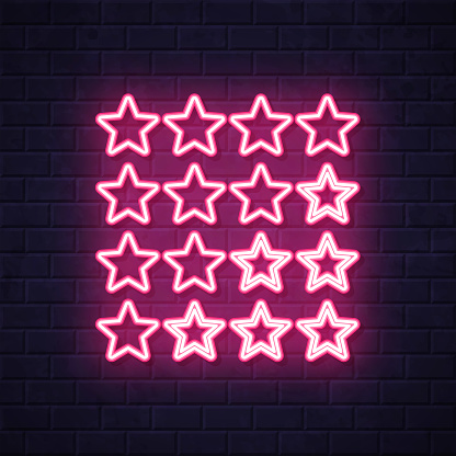 istock Star rating. Glowing neon icon on brick wall background 1731130414