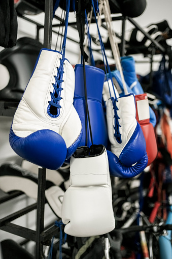 Boxing gloves hanging on metal rack in boxing club gym