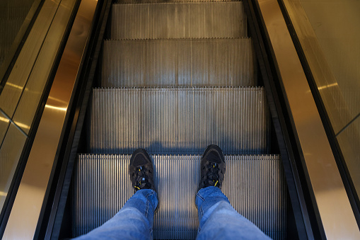 Male feet standing on escalator