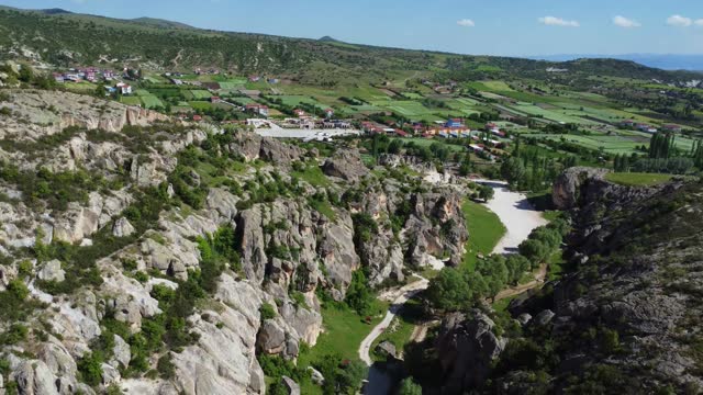 4k aerial video of the village between the mountains, with green areas, adjacent to the ancient city