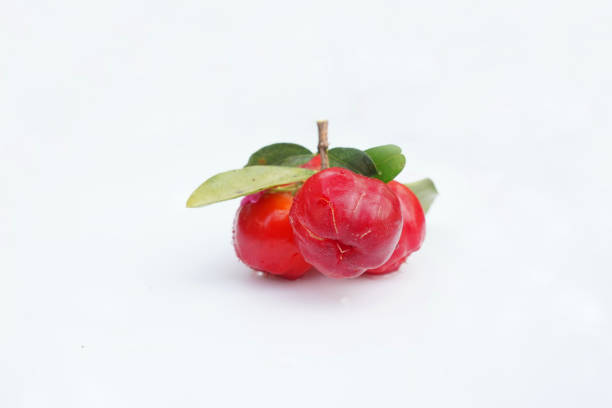 Fresh acerola fruit, typical from Brazil. Red organic Acerola Cherry with half slice and green leaves isolated on white background, High vitamin C and Antioxidant fruits