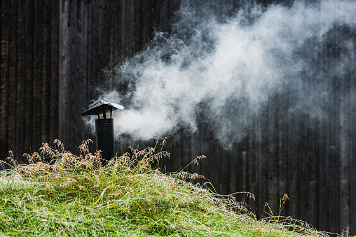 Chimney releasing smoke from traditional Lapp cot in rural Sweden.