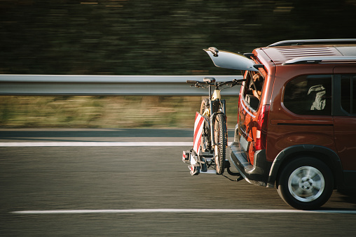 Car in motion on a highway carrying a mountain bike on its rear