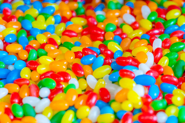 A bowl of colorful marshmallow candy is piled high on a buffet table.