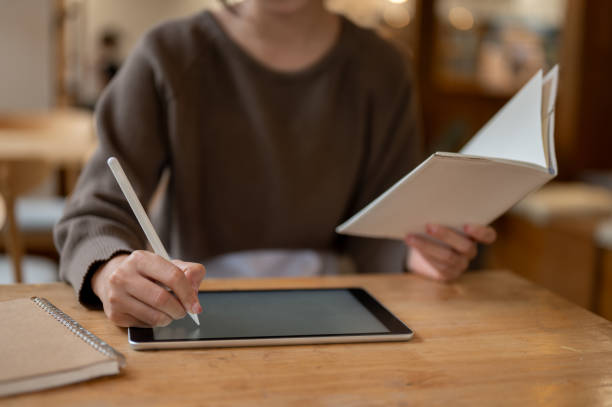 istock A woman taking notes or working on her digital tablet, working remotely at a coffee shop. 1731229758