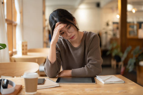 istock A stressed Asian woman is concerned about her project's deadline while working remotely at a cafe. 1731231930