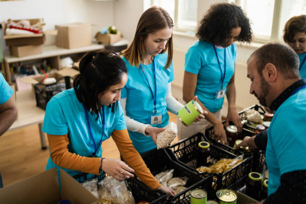 Charity workers packing food donations stock photo