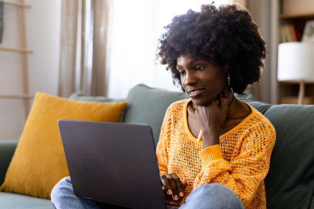 istock Young woman using laptop in living room 1731262100