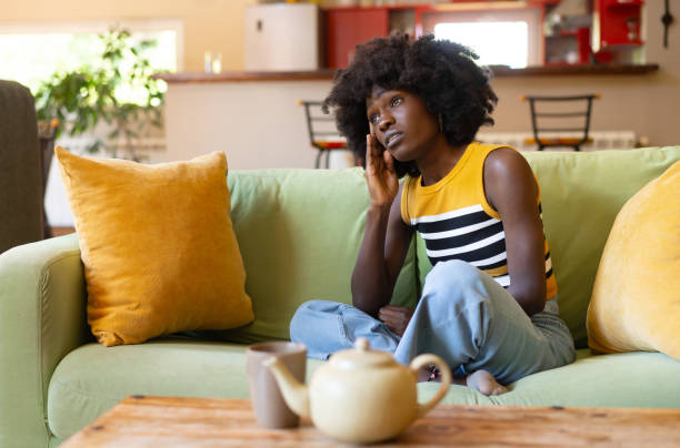 istock Sad woman sitting on sofa at home 1731262659