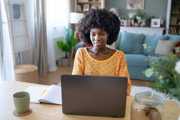 Woman working on laptop at home stock photo