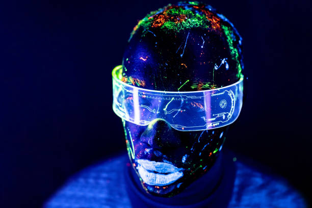 Portrait of a man painted in fluorescent UV colours with cyberglases looking at camera