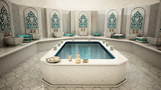 A pool standing at the center of a traditional Turkish bath (Hamam) with beauty products, towels and candles. Wellbeing concept.