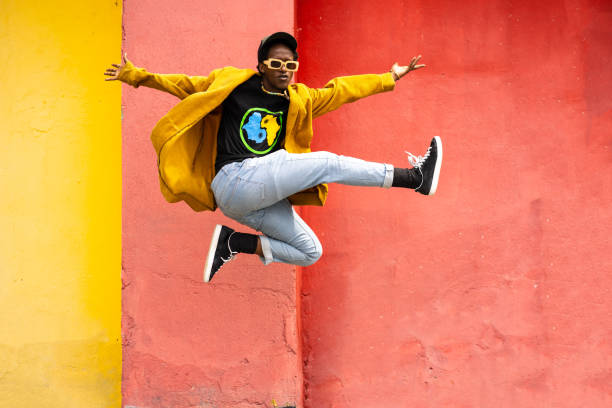 un jeune homme africain excité saute - hip hop hipster afro men photos et images de collection