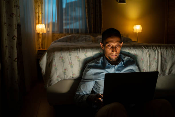 istock Man in bed watching laptop at night 1731264472