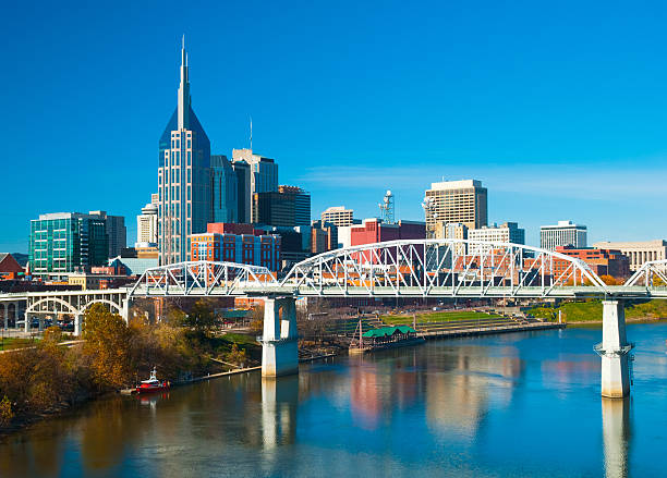 Nashville skyline, bridge, and river Downtown Nashville skyline with the Shelby Street bridge and the Cumberland River. nashville tennessee bridge stock pictures, royalty-free photos & images