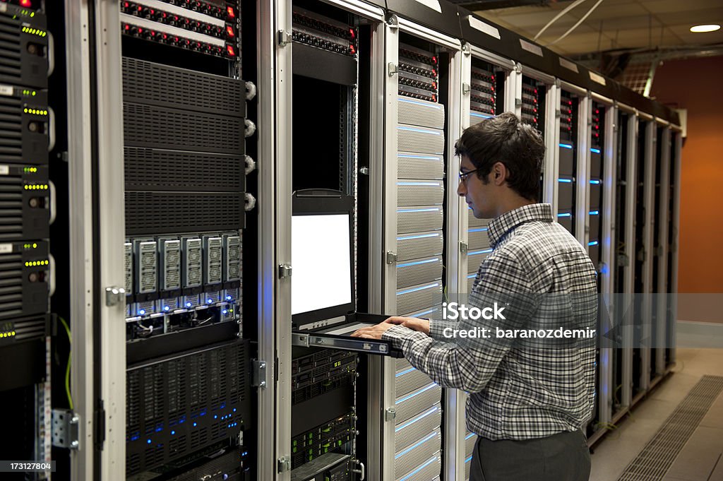 O engenheiro trabalhando em um centro de dados do servidor - Foto de stock de Engenheiro royalty-free
