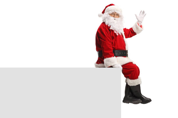 istock Santa Claus sitting on a wall and waving 1731278669