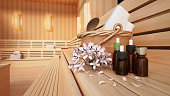 Massage oils, traditional accessories and towels standing on a Finnish sauna seat. Wellbeing concept