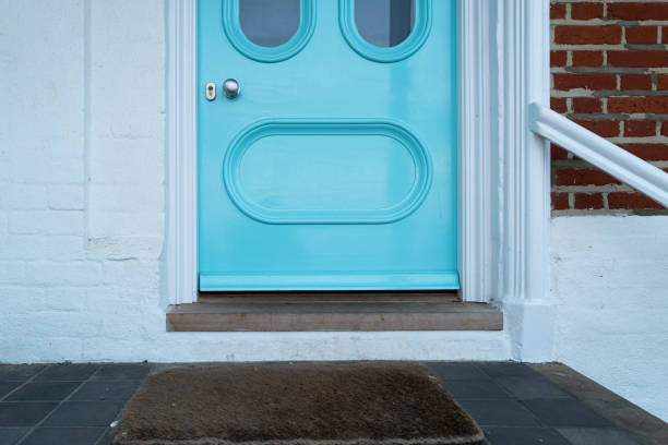 Unusual front door, with the door knob and lock seen very low. Unusual front door, with the door knob and lock seen very low compared to normal front doors. Showing a colour hue of blue. key doormat stock pictures, royalty-free photos & images