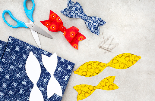 Steps to make your own fabric bow with bold printed African fabric on grey
