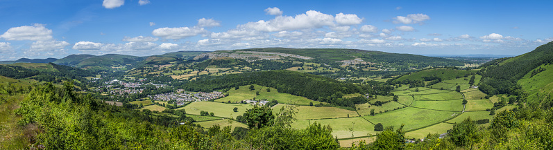 Big blue summer skies and white fluffy clouds above country villages, rolling hills, green fields and the picturesque patchwork pasture of this rural panorama from high above.