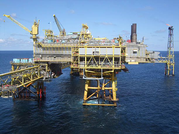 Offshore oil production platform An offshore oil production platform connected by to other platforms in the complex by walkway north sea oil and gas stock pictures, royalty-free photos & images