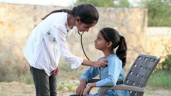 Female doctor or pediatrician with stethoscope listening to heartbeat boy's patient on medical exam at clinic. kid boy on medical examination checkup
