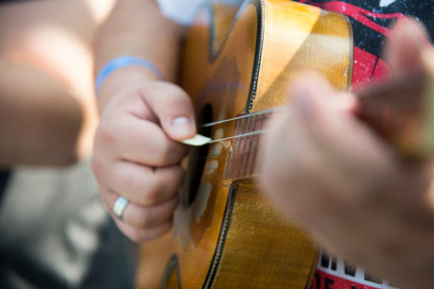 Man's hand playing acoustic guitar