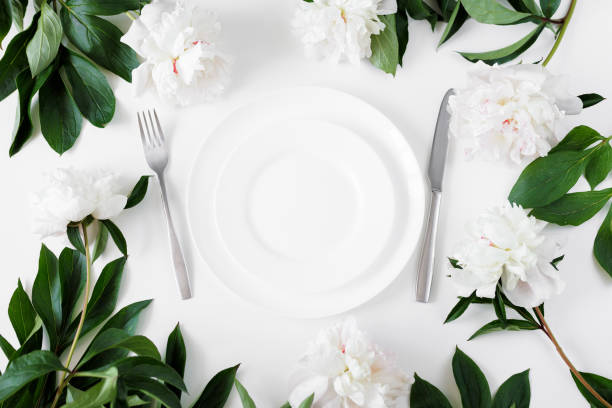istock Festive table setting with white plate, cutlery and peonies 1731338959