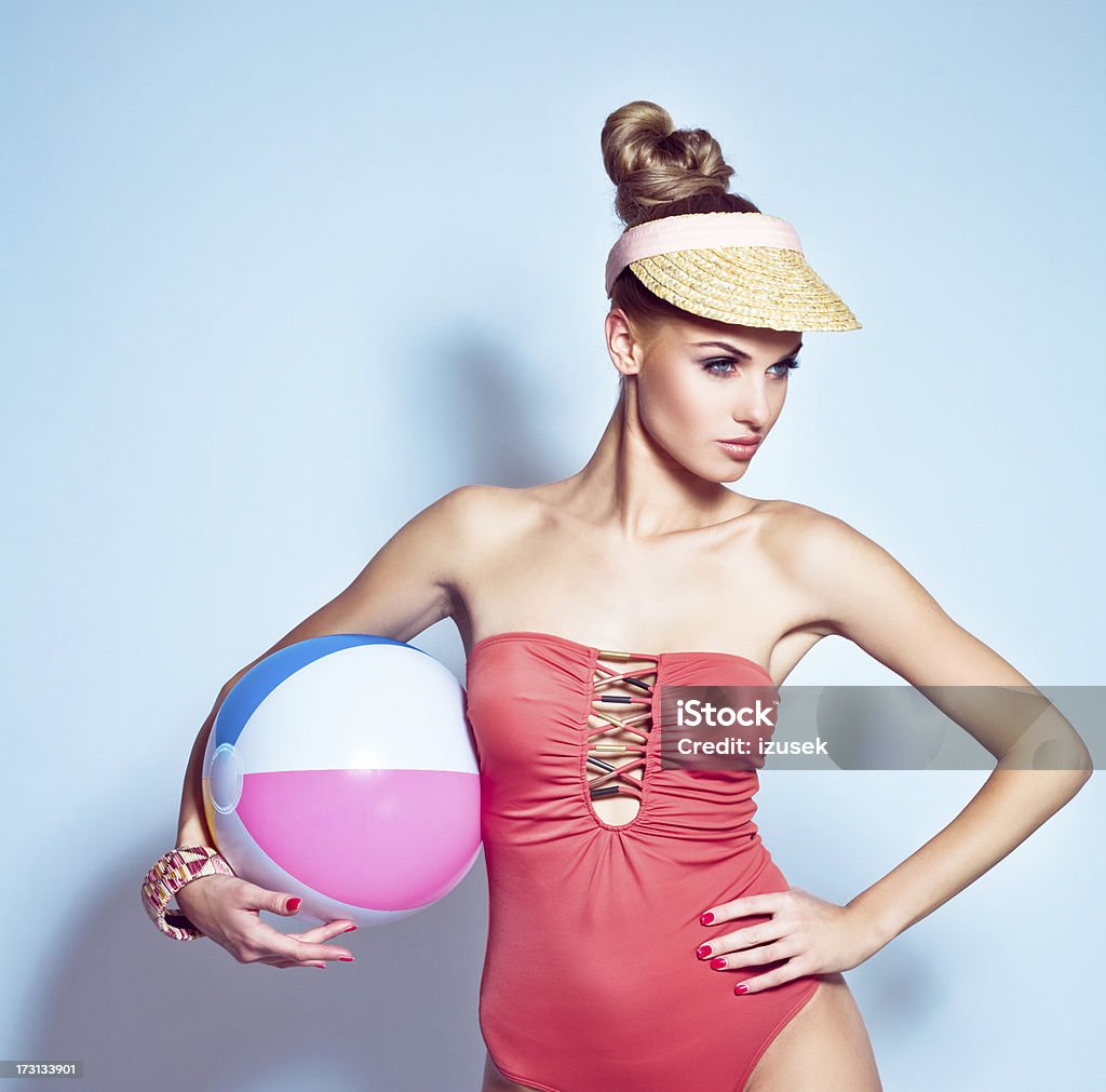 Summer Beauty Summer fashion portrait of beautiful, confident young adult woman wearing fashionable swimwear and holding beach ball. Studio shoot. Beach Ball Stock Photo